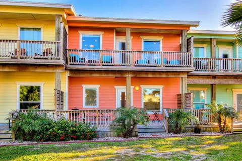 Vibrant waterfront cottages create a cheerful tropical retreat with private balconies and lush landscaping.