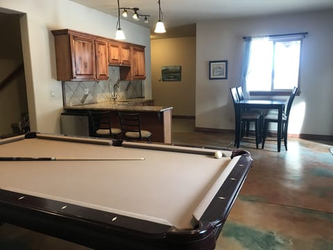 Wet bar,  mini fridge, and eating area in bright walkout level