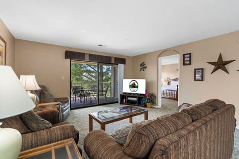Living area features a queen sleeper sofa, cable TV, a new smart TV, DVD player, VCR, and direct balcony access!