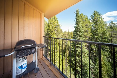 Your private balcony features a gas grill for outdoor cooking while enjoying peaceful forest views through towering evergreens.
