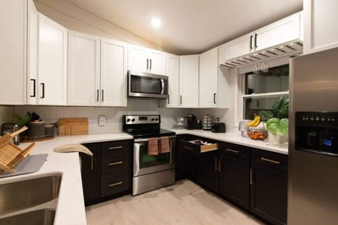 Bake pizza, lasagna, cookies, and pie with electric heat! Enjoy the fully renovated kitchen featuring stunning quartz countertops and sleek stainless steel appliances. This kitchen is fully stocked with all the cookware, utensils, glassware, a