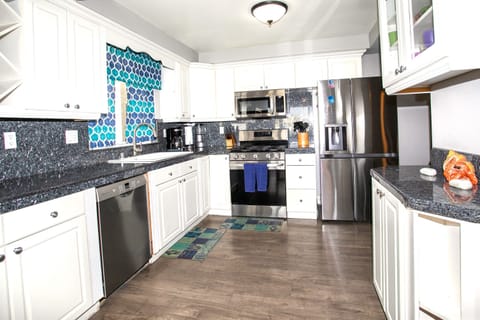 The kitchen includes a refrigerator with an ice maker, dishwasher, stove, oven, and microwave.