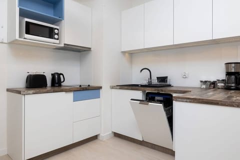 Kitchenette with plenty of kitchen utensils and dishes. 