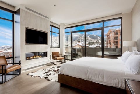 Exquisite main bedroom suite with private patio, floor to ceiling windows and quartz feature fireplace wall with large screen TV