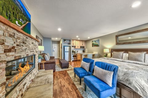Cozy up in your stylish studio with crackling fireplace, plush seating, and modern kitchen—your perfect mountain retreat sanctuary.