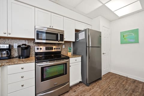 Fully stocked kitchen with stainless steel appliances.