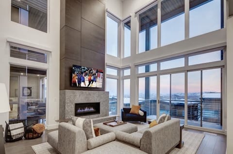 Great room with massive wall of windows looking out towards the valley and Uinta mountains
