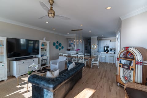 New 75 inch TV in the main living area with comfortable beachy furnishings