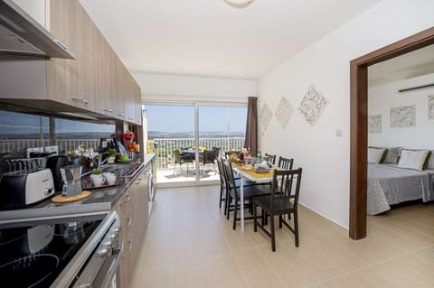 fully equipped kitchen and dining area overlooking the sunny terrace with views