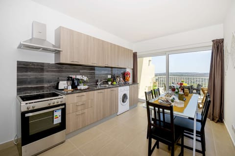fully equipped kitchen and dining area overlooking the sunny terrace with views