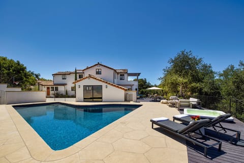 Outdoor space stuns with large pool and adjacent hot tub