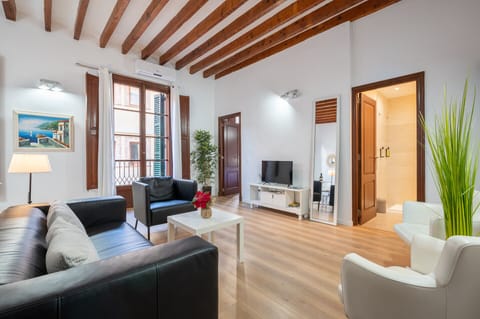 The living room of this holiday apartment Holiday Palma Apartment 2 has air conditioning, sofa, tables, TV, for a comfortable stay.