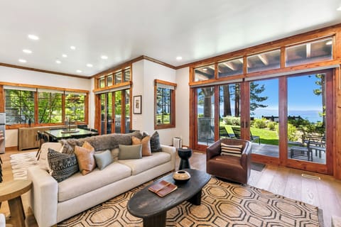 Relax in this spacious living room where floor-to-ceiling windows frame stunning lake views.