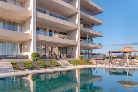 Velamar’s sparkling community pool, surrounded by lounge chairs and umbrellas.