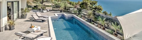 Spacious fenced terrace with private pool surrounded by sun loungers and seaview from the property of the luxury villa Happiness