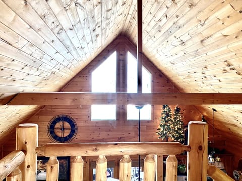 Cathedral ceilings frame windows allowing glowing natural light and night sky.