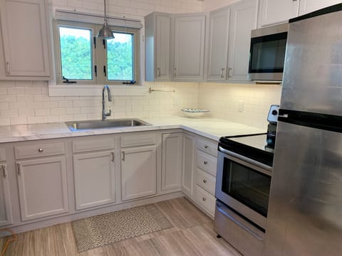 Kitchen with stove, fridge, Kohler farm sink, microwave and all the necessities