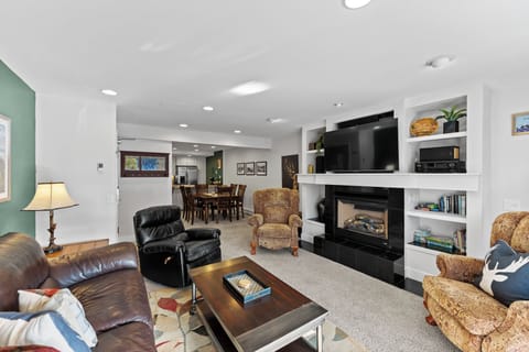 Sink into plush leather seating by your cozy fireplace, with entertainment center and shelving creating the perfect relaxation retreat.