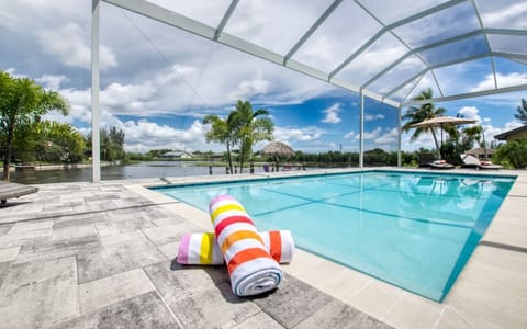 Heated pool with colorful beach towels on the paver deck