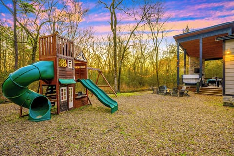 Outdoor Playset with swing and slide, facing the seasonal creek