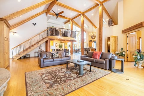Relax in your spacious living room with soaring timber ceilings and warm hardwood floors creating the perfect mountain retreat atmosphere.