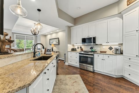 Kitchen: Stainless steel appliances, gas range, granite countertops, wine cooler, 2-person bar seating
