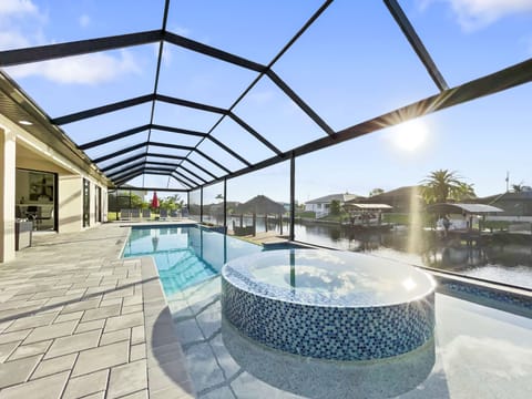 Screened heated pool and spa with paver deck and wide open views