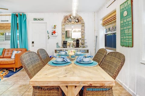 Enjoy dining in this bright, coastal-inspired space featuring woven chairs, beach décor, and an inviting atmosphere for memorable meals together.