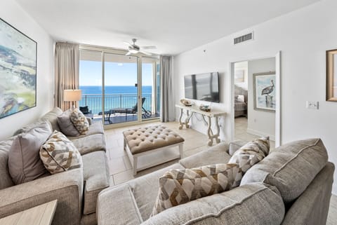 Relax in your bright living room with stunning ocean views through floor-to-ceiling windows and comfortable seating.