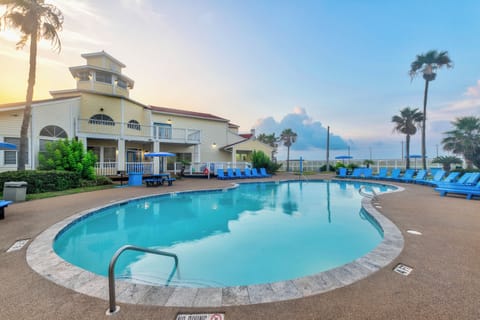 Resort pool area featuring tropical palms and comfortable lounge seating in a peaceful waterfront setting.