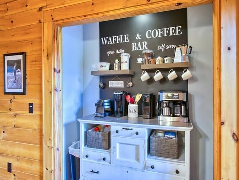 Coffee bar with Keurig, espresso machine, coffee grinder, and waffle maker.