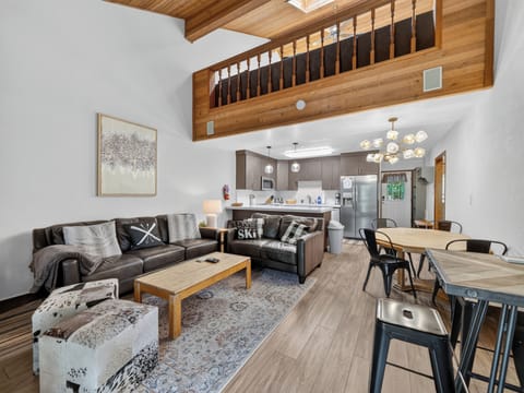 Picture yourself here: soaring vaulted ceilings with a cozy loft above, a sleek open kitchen, and plush leather seating perfect for gathering with friends and family in your mountain getaway.