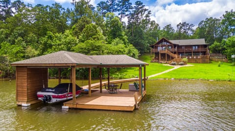 large grassy backyard with stone pathway from main home to boathouse .and lake