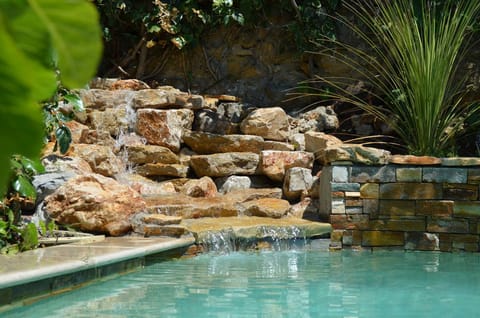 Outdoor pool, a waterfall pool, open 9:30 AM to 7:00 PM, pool umbrellas