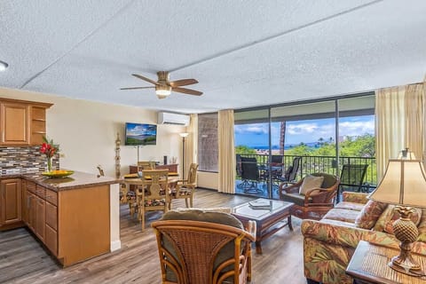 Bright open living space w/ sofa seating, dining table & sliding doors to a breezy balcony. Split AC