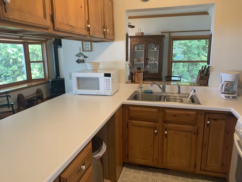 Well equipped kitchen with bar seating area. View out over water.
