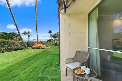 Sip coffee by the sea on your private lawn surrounded by palms and blooms.
