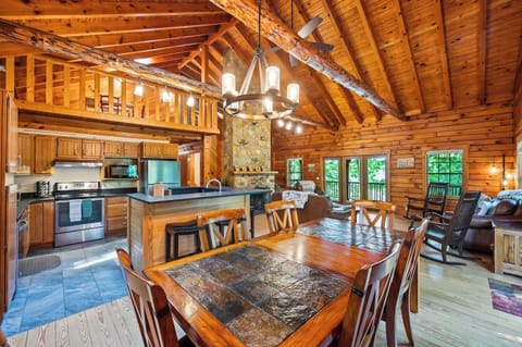 This enormous great room with soaring , wood burning fireplace is totally open with lots of seating, fully stocked kitchen and slate topped dining table with seating up to ten. 