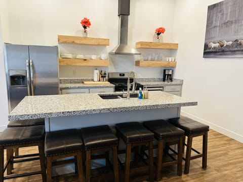 Kitchen Island with seating, dishwasher, refrigerator, microwave.