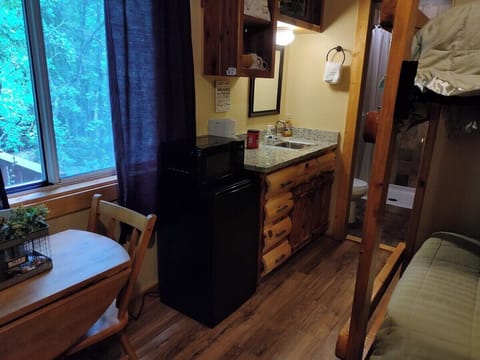 MAIN ROOM: Includes two twin-on-twin bunk beds, a small dining table, chairs, and a kitchenette / sink.