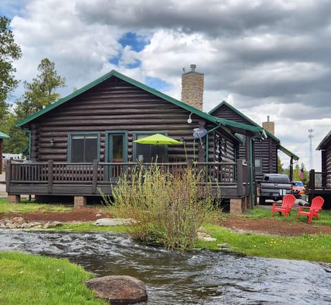 Back side of cabin facing  ponds & meadow area. Just below the Adirondack chairs is  Little Colorado River. A nice place to sit & fish or just enjoy the fresh air. Our porch has 3 cafe  tables and six padded chairs next & propane grill. Gas provided.