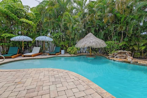 Your private tropical oasis awaits with sparkling pool, shaded loungers, tiki bar, and lush palms—perfect for lazy afternoons and cocktails under the sun.