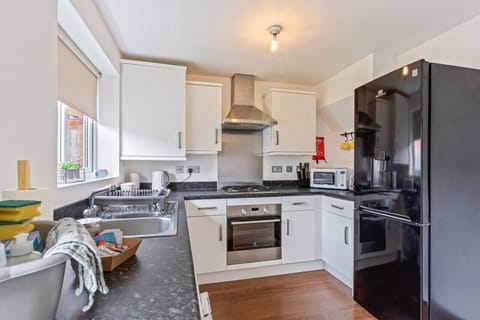 A fully equipped kitchen with fridge freezer, oven, stove, microwave, kettle, toaster, cookware, tableware, and utensils all provided