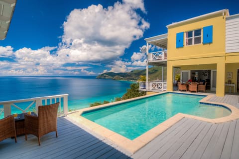 The pool deck has various seating arrangements and sun loungers
