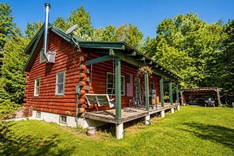 Beautiful log cabin with porch swing — your serene nature escape.