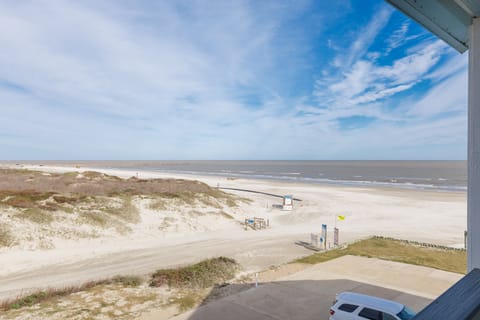 Expansive beachfront stretches endlessly before this coastal property, with pristine sand dunes and rolling waves creating a peaceful seaside setting.