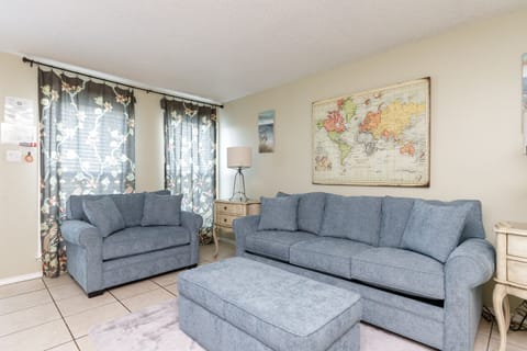Relax in comfort with plush blue sofas and inspiring world map art in your bright, welcoming living space.
