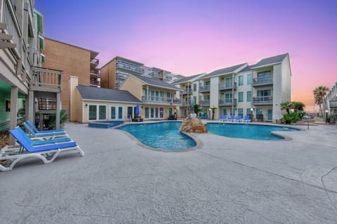 Beautiful resort complex with swimming pool and multiple buildings showcasing stunning sunset sky colors.
