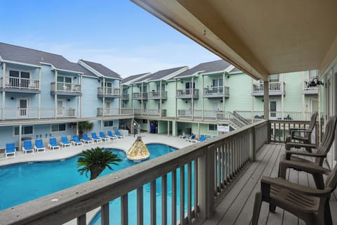 Step onto your private balcony and soak in stunning pool views while colorful beach buildings create a charming coastal backdrop for your getaway.