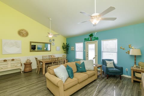 Relax in this bright, coastal-themed living space where turquoise accents and beach decor create your perfect vacation vibe.